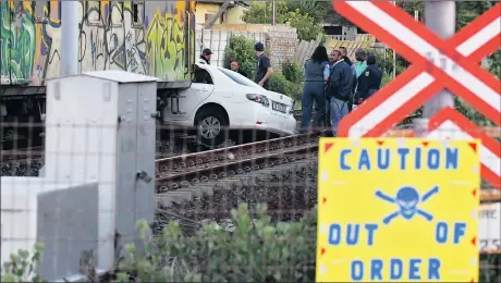  ?? Picture: JEFFREY ABRAHAMS ?? COLLISION: A Metrorail passenger train dragged a car about 50m after a crash at the Uxbridge Road level crossing in Lakeside yesterday.