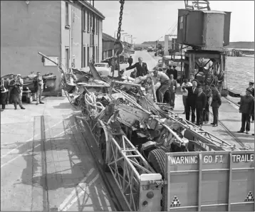  ??  ?? The wreckage of the plane is lifted on to a trailer at Rosslare Harbour shortly after the crash.