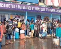  ??  ?? PASSENGERS who arrived by long distance trains waiting for transport outside the Howrah railway station during a complete lockdown in West Bengal on July 23.