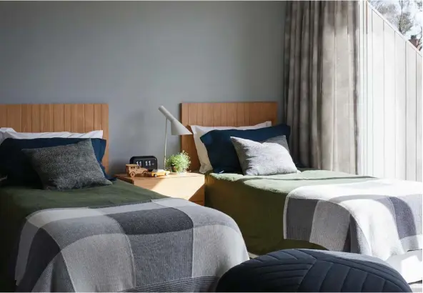  ??  ?? ABOVE The twin beds in the kids’ room have grooved-ply headboards that will slot together seamlessly if the room ever needs to be updated with a double bed. Bedding from Thread Design, blankets from Atelier Textiles and a Five pouf by Muuto from Bauhaus complete the look.