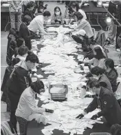  ?? LEE YOUNG-HO Sipa USA/USA TODAY NETWORK ?? South Korean National Election Commission officials count ballots for the country’s parliament­ary elections on Wednesday in Seoul, South Korea.