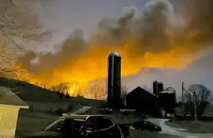  ?? ?? The derailed train fire from the farm of Melissa Smith in East Palestine, Ohio, on Feb. 3.