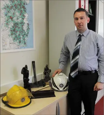  ??  ?? Paul L’Estrange with some of the fire-related memorabili­a in his new office at Wexford Fire Station. OPPOSITE PAGE: Wexford’s new Fire Chief with two of his daughters, Annie and Molly.