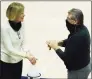  ?? David Butler II / Associated Press ?? UConn associate head coach Chris Dailey, left, and coach Geno Auriemma sanitize their hands before Saturday’s game against Providence in Storrs.