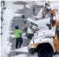  ?? AP ?? A worker clears snow off school buses, after schools were closed due to a storm, in Manchester, New Hampshire. —