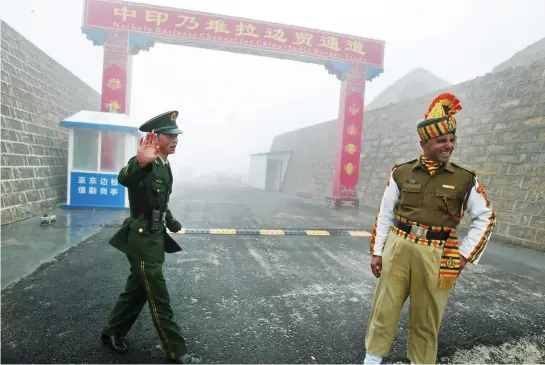  ??  ?? A Chinese soldier, left, next to an Indian soldier at the Nathu La border crossing in India's northeaste­rn Sikkim state, in this file photo. (AFP)