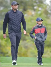  ?? Associated Press photo ?? Tiger Woods, left, walks with his son Charlie after hitting their tee shots on the 10th hole during a practice round at the Father Son Challenge golf tournament in Orlando, Fla.