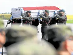  ??  ?? HONORS FOR THE FALLEN The remains of three of the four Army intelligen­ce officers shot dead by the police in Jolo, Sulu, on Sunday arrive at Villamor Air Base on Tuesday.
