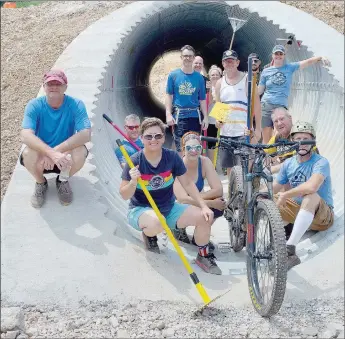  ?? Keith Bryant/The Weekly Vista ?? After a busy morning cutting trail, a group of volunteers pose in the newly-installed, not-quite-finished tunnel under Chelsea Road.