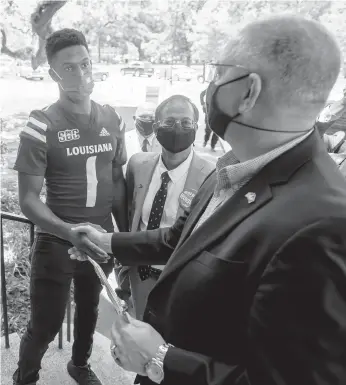  ?? SCOTT CLAUSE/THE DAILY ADVERTISER VIA AP ?? Louisiana quarterbac­k Levi Lewis greets Gov. John Bel Edwards as he tours the University of Louisiana campus COVID-19 vaccinatio­n site in August as part of the university’s Shot for $100 campaign.