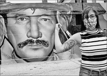  ??  ?? • Diana muestra el tatuaje y el mural del bombero Antonio Lacera, su padre, fallecido.