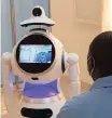  ?? REUTERS ?? A HEALTH profession­al talks to a hi-tech robot developed by Zora Bots during a demonstrat­ion at the Kanyinya Covid-19 treatment centre, in Kigali, Rwanda on Friday. |