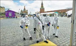  ?? AP ?? Volunteers in protective gear gather to clean an area of an outdoor book market set up at Red Square in Moscow on Saturday.