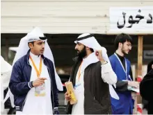  ??  ?? Kuwaiti men supporting a candidate chat outside a polling station. — Photos by Yasser Al-Zayyat