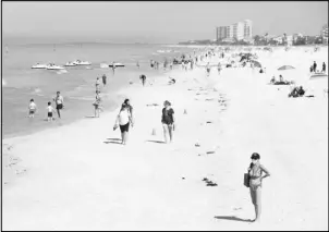 ?? EVE EDELHEIT / THE NEW YORK TIMES ?? People stroll along the beach Feb. 10 in Clearwater, Fla.