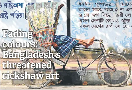  ?? — AFP photos ?? A bicycle rickshaw driver resting in his vehicle by a street kerb in Dhaka.