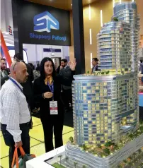  ?? — Photos by Leslie Pableo and Juidin Bernarrd ?? Visitors check out a scale model of District One Residences in Mohammed Bin Rashid Al Maktoum City; right, a saleswoman explains features of Shapoorji Pallonji’s Imperial Avenue project in Downtown Dubai on the third day of Cityscape Global. The event...