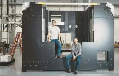  ?? SIMON SIMARD/THE NEW YORK TIMES ?? VulcanForm­s founders Martin Feldmann, left, and John Hart pose June 2 with the frame of a 3D printer at their facility in Devens, Mass. With the technology improving and costs falling, 3D printing may be ready for a major role in manufactur­ing.