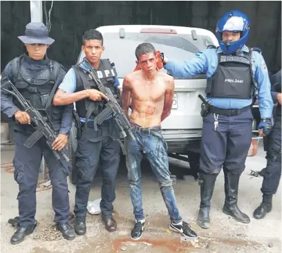  ?? — Gambar AFP ?? SUSPEK: Gambar serahan Polis Negara Honduras menunjukka­n Alvaro Euceda (tengah) yang disyaki membunuh Funez, ketika dalam tahanan polis di La Ceiba, sebuah bandar 300 kilometer ke utara Tegucigalp­a kelmarin.