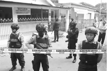  ??  ?? Police stand guard near the home of a suspected militant, following his arrest in Singosari District, Malang, Indonesia. — Reuters photo