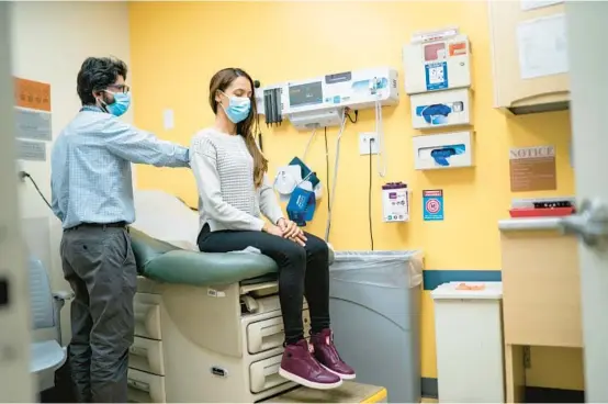  ?? EDUARDO MUNOZ ALVAREZ/AP PHOTOS ?? Dr. Matthew Kusher, clinical director of Plaza del Sol Family Health Center, examines a patient Jan. 11 in the Queens borough of New York City.