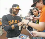  ?? Ralph Freso / Getty Images 2015 ?? Brandon Crawford before a spring game in 2015. The Giants open their Cactus League season Sunday at Scottsdale Stadium.