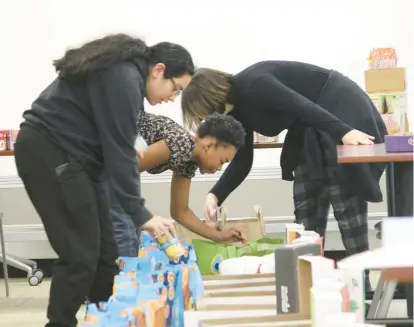  ?? HIGH SCHOOL DISTRICT 218 PHOTOS ?? Leo Club members pack donations at Eisenhower High School in Blue Island.