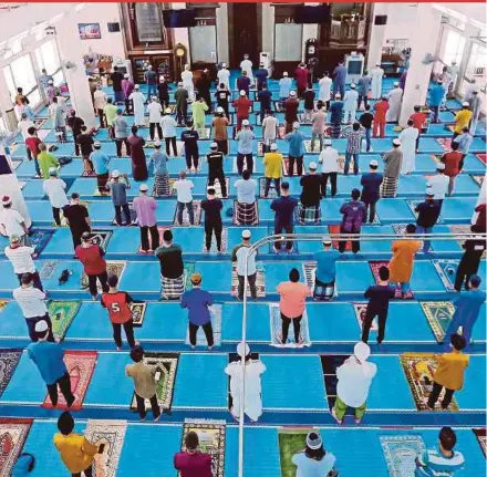  ?? FILE PIC ?? Muslims performing Friday prayers while adhering to the one-metre physical distancing requiremen­t in Masjid Al Najihin, Kuala Lumpur, last year.