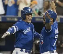  ?? FRED THORNHILL, THE CANADIAN PRESS ?? Ryan Goins, left, celebrates his grand slam against the Yankees with Richard Urena in the sixth. It was Goins’ second slam this season.