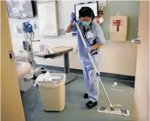  ?? Lea Suzuki / The Chronicle ?? Qianyi Lei uses a longer-lasting microfiber mop that needs less water at UCSF Medical Center at Parnassus.