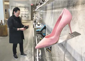  ?? Haven Daley / Associated Press ?? Personal shopper and stylist Kat Yeh looks at shoes for a client in San Francisco. One of the fastestgro­wing job categories of the past decade has been catering to the whims of the wealthy.