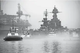  ?? PHOTOS BY BRETT COOMER/HOUSTON CHRONICLE ?? The Battleship Texas emerges from the fog as it leaves a drydock Tuesday in Galveston. After 18 months of hull restoratio­n, the Texas reentered the water and moved to a nearby dock as part of a $70 million restoratio­n of the historic battleship.