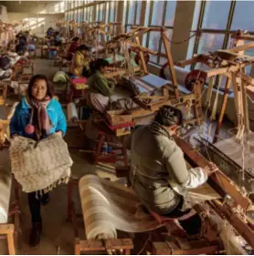  ??  ?? Craftspeop­le weave coarse cloth in a factory in Hengshui, Hebei Province in north China, on December 25, 2018