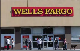  ?? (AP) ?? Customers line up outside a Wells Fargo branch in Los Angeles in this file photo from April. The Federal Reserve this week ordered the banks to suspend stock buybacks and dividend payouts until Sept. 30.