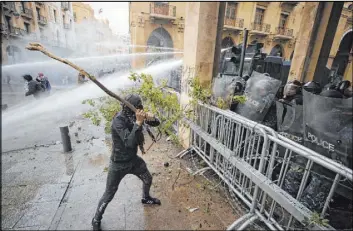  ?? Hassan Ammar The Associated Press ?? Anti-government demonstrat­ors clash with riot police Saturday at a road leading to the parliament building in Beirut. Lebanon has endured three months of protests.