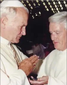  ??  ?? Fr Chris with Saint John Paul and right, kissing the ring of Pope Paul