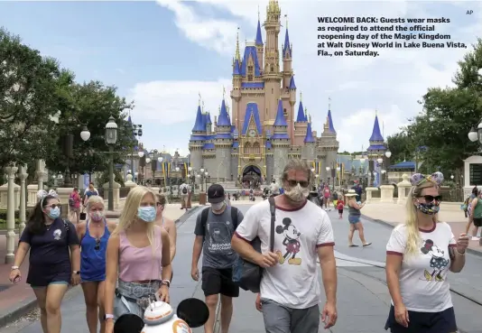  ?? AP ?? WELCOME BACK: Guests wear masks as required to attend the official reopening day of the Magic Kingdom at Walt Disney World in Lake Buena Vista, Fla., on Saturday.