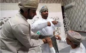  ?? Mohammed Mahjoub / AFP ?? Omani grooms dress ahead of a mass wedding ceremony in Al Mudhaibi province