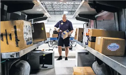  ?? [CHRIS LANDSBERGE­R/ THE OKLAHOMAN] ?? FedEx delivery driver Mickey Stanley sorts packages for delivery at the FedEx offices in Oklahoma City.