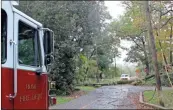  ?? John Bailey ?? Firefighte­rs wait on Georgia Power crews early Thursday after a tree knocked down power lines on Sherwood Road.