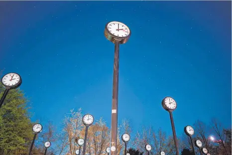  ?? FOTO: FABIAN STRAUCH/DPA ?? Das Kunstwerk „Zeitfeld“von Klaus Rinke im Düsseldorf­er Volksgarte­n. Die Uhren zeigen auf zwei Uhr in der Nacht.