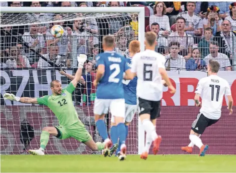  ?? FOTO: MARIUS BECKER/DPA ?? Ins Netz gegangen: Deutschlan­ds Marco Reus (rechts) trifft gegen Estlands Torwart Sergei Lepmets zur 1:0 Führung.
