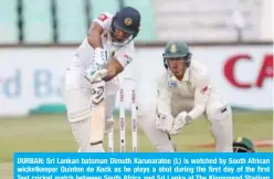  ??  ?? DURBAN: Sri Lankan batsman Dimuth Karunaratn­e (L) is watched by South African wicketkeep­er Quinton de Kock as he plays a shot during the first day of the first Test cricket match between South Africa and Sri Lanka at The Kingsmead Stadium in Durban yesterday. —AFP