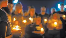  ?? L.E. Baskow Las Vegas Review-journal @Left_eye_images ?? A silent prayer is said during a candleligh­t vigil for 19-year-olds Harlee Andrew Deborski and Timothy Allen Bailey at Desert Breeze Park on Monday.