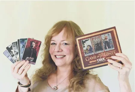 ??  ?? Author Liz Dean and her tarot cards produced in conjunctio­n with Game of Thrones.