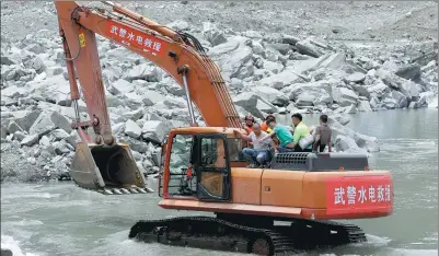  ?? FENG YONGBIN / CHINA DAILY ?? Soldiers of the People’s Armed Police Hydropower Forces move people affected by the landslide to safety using an excavator in Maoxian county, Sichuan province, on Sunday.