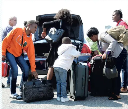  ?? PHOTO FRÉDÉRIQUE GIGUÈRE ?? Fraîchemen­t débarqués d’un autobus à l’arrêt de Plattsburg­h, dans l’état de New York, des dizaines de migrants sautent ensuite dans un taxi jusqu’à la frontière canadienne, où ils traversero­nt illégaleme­nt au Québec.