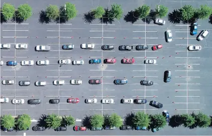  ?? STEPHEN M. KATZ/STAFF FILE ?? Cars wind through a TCC Portsmouth campus parking lot as residents wait for drive-through coronaviru­s tests on May 23. A new report estimates that 1 in 10 Hampton Roads workers received some form of unemployme­nt compensati­on at the height of the pandemic’s effects.