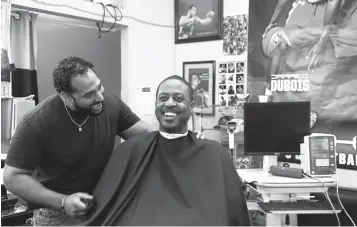  ?? Associated Press ?? ■ Barber Eric Muhammad, owner of A New You Barbershop, left, jokes with regular customer Marc M. Sims before measuring his blood pressure Sunday in Inglewood, Calif. Black male customers at dozens of Los Angeles-area barbershop­s reduced one of their...