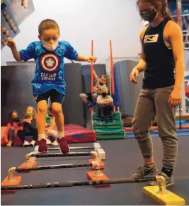  ?? ADOLPHE PIERRE-LOUIS/JOURNAL ?? Instructor Sowelu Lottimer watches 5-year-old Jack McElvany jump during a parkour class Jan. 7 at Ninja Force Obstacle Gym. at 5812 Signal NE.